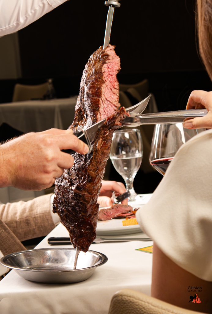 Server carving grilled Brazilian steak tableside at Chama Gaucha steakhouse